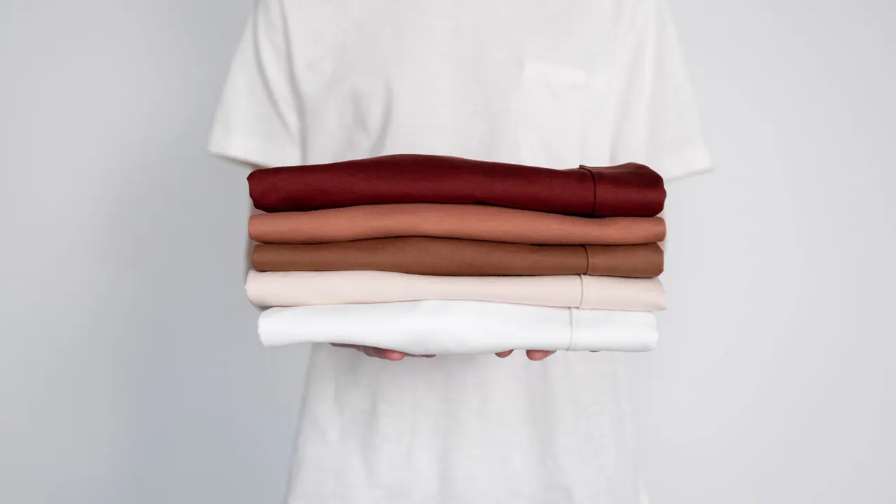 Stacks of folded custom t-shirts in a range of colours