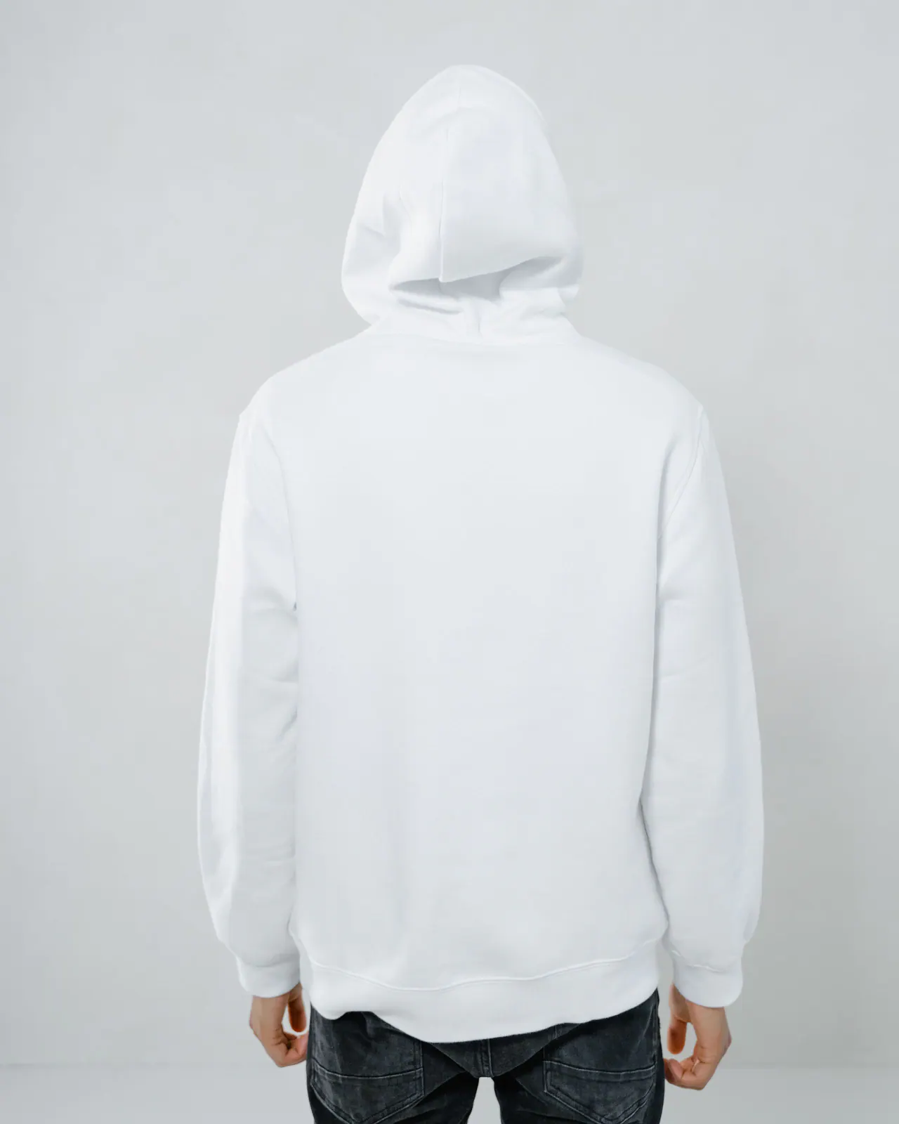 Person wearing a plain hoodie in a studio
