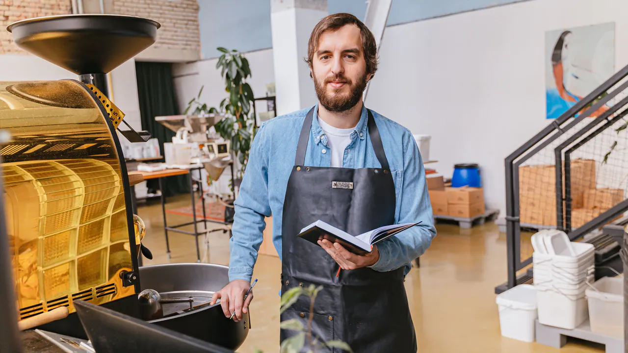 A barista in an apron at a cafe