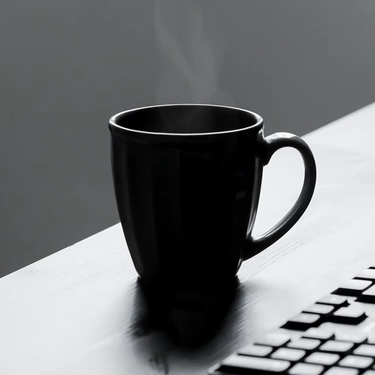A mug on a desk with a laptop